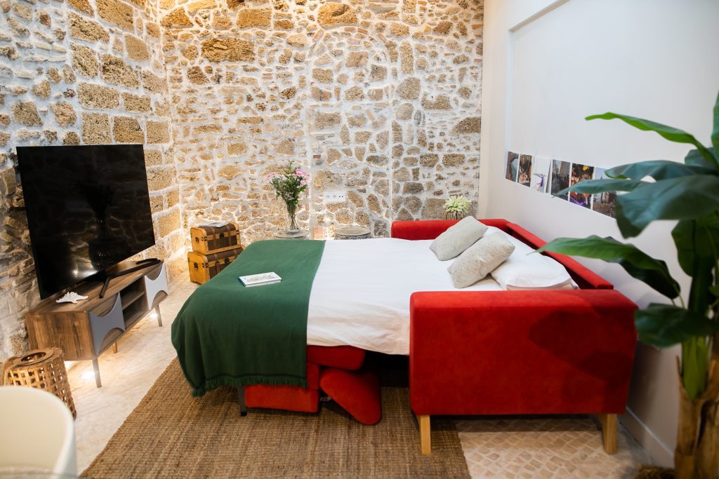 Sofá cama abierto Salón de Casa Señorial Rivadavia con sofá cama convertido en cama doble y televisión frente a la zona de descanso