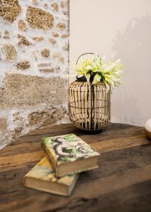 Detalle de decoración con libros y flores sobre mesa de madera en Casa Señorial Rivadavia