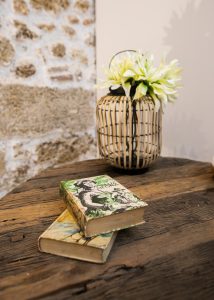 Mesa de madera con libros y centro floral decorativo en Casa Señorial Rivadavia