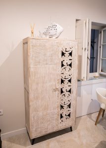 Mueble auxiliar de madera tallada con decoración en el salón de Casa Señorial Rivadavia