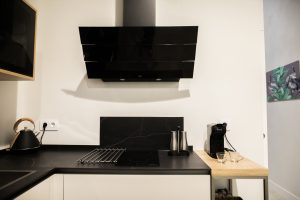 Cocina totalmente equipada de Casa Señorial Rivadavia con placa de inducción, campana extractora y cafetera
