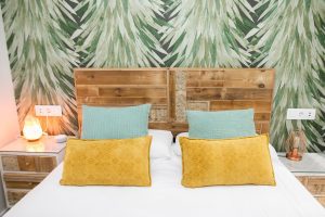 Cabecero de madera artesanal con papel pintado tropical en el dormitorio principal de Casa Señorial Rivadavia