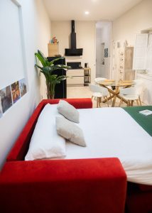 Estudio diáfano de Casa Señorial Rivadavia con sofá cama abierto, cocina equipada y comedor integrado