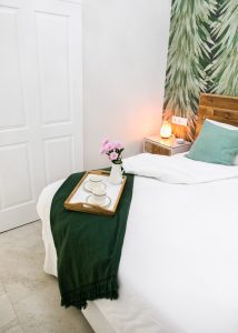 Habitación doble de Casa Señorial Rivadavia con bandeja de desayuno, lámpara ambiental y cabecero de madera