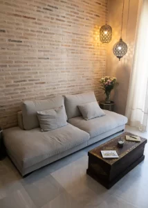 Salón con sofá, pared de ladrillo visto y decoración elegante en Palacio Conde Casa-Brunet
