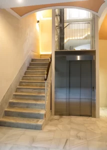 Escalera de mármol y ascensor interior en Palacio Conde Casa-Brunet