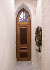 Pasillo con puerta de madera de estilo neogótico en Palacio Conde Casa-Brunet