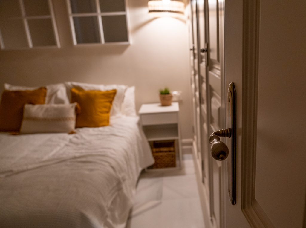Dormitorio visto desde la puerta Vista del dormitorio desde la puerta, con cama doble, mesilla y ambiente cálido en Casa Apolo.