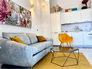 Salón con sofá y cocina integrada de Casa Señorial Rivadavia, apartamento turístico en el centro histórico de Cádiz