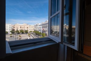 Ventana abierta del apartamento Casa Apolo con vistas a la Plaza de San Juan de Dios de Cádiz.