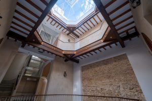 Vista del patio interior con cubierta acristalada y arquitectura histórica rehabilitada del edificio Casa Apolo.