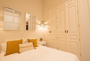 Dormitorio con cama de matrimonio, armarios empotrados y decoración elegante en Casa Apolo.