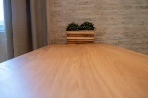 Primer plano de la mesa del comedor con decoración y acabados cálidos del apartamento Casa Apolo.