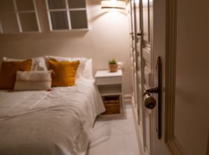 Vista del dormitorio desde la puerta, con cama doble, mesilla y ambiente cálido en Casa Apolo.