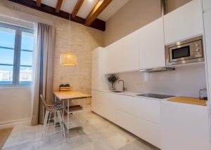 Cocina moderna integrada junto al comedor con ventana exterior en Casa Apolo.